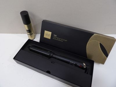 un stylo noir dans une boîte noire, à côté d'un flacon de parfum