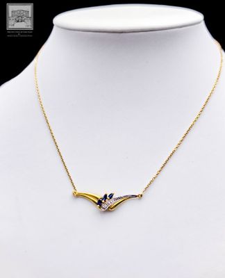 a gold necklace with a blue and white bird on it