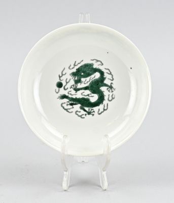 une image représentant une assiette sur laquelle est peint un dragon vert