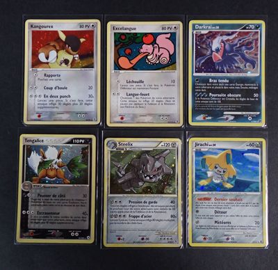 Plusieurs cartes Pokémon sont disposées sur une surface noire