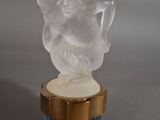 une figurine d'ange posée sur un vase bleu