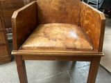 a wooden chair with a leather seat in a room
