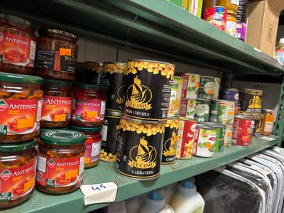 de nombreux bocaux de conserve sur une étagère dans un magasin