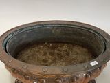 a metal bowl with a handle on a white surface