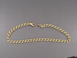 gros plan d'un bracelet en chaîne en or sur une table