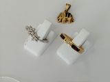 two pairs of gold and white cuff rings and a tag