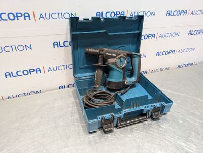 une boîte bleue contenant une perceuse, posée sur une table