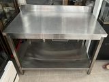 une table en acier inoxydable surmontée d'une vitrine en verre