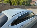 a silver car parked in a parking lot next to a brick wall