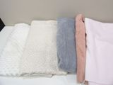 three blankets are stacked on top of each other on a table