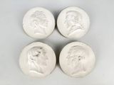 four white marble medallions with heads of men and women
