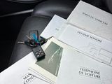 papers and a cell phone sitting on the back seat of a car