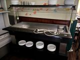 une photo d'une cuisine avec un évier et de la vaisselle posée sur le plan de travail