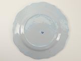 a plate with a blue flower on it on a white table