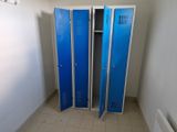 two blue lockers in the corner of a room