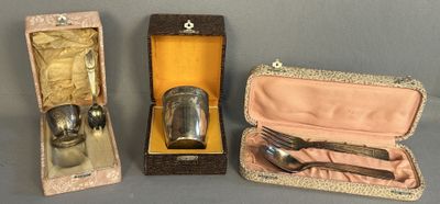 three silverware items sitting in a case on a table