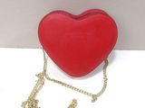 a red heart shaped purse with a gold chain