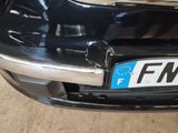 the front bumper of a black car with a license plate on it