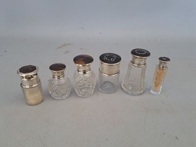 six petites salières et poivrières en verre alignées sur une table