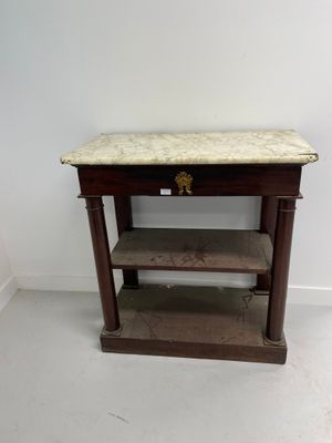 an old wooden table with a marble top in a white room