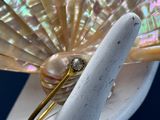 une bague en or sertie d'un diamant, posée sur un parapluie blanc