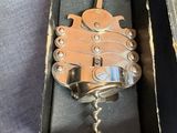 a bottle opener in a box with a corkscrew in it