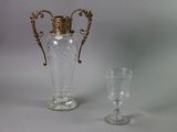 a vase and a wine glass sitting next to each other