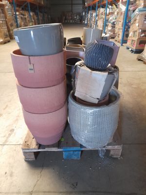 une pile de casseroles posée sur une palette dans un entrepôt