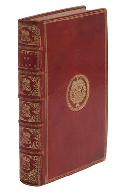 un vieux livre rouge orné d'un médaillon doré sur la couverture