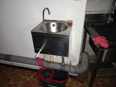 a sink and a bucket on the floor in a room