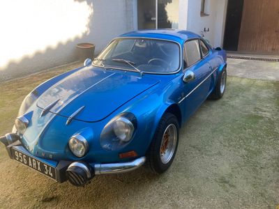 une voiture de sport bleue garée devant une maison