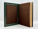 an open book sitting on top of a white table next to a white wall