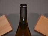 a bottle of wine sitting on a table next to a block of wood