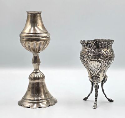 deux vases en argent posés l'un à côté de l'autre sur une surface blanche