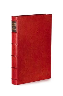 a red book with a black binding on top of it