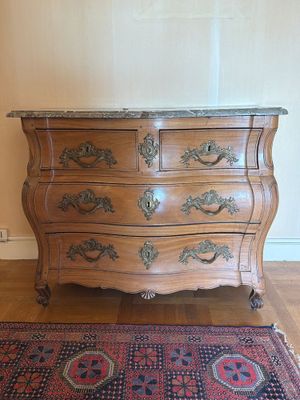 une commode en bois posée sur un tapis, à même le sol