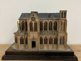 a small model of a building on a wooden table