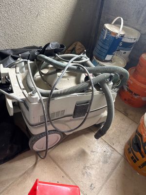 un tas d'appareils électriques posé par terre à côté d'une poubelle