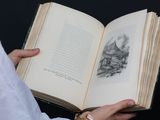 a person holding an open book in their hands