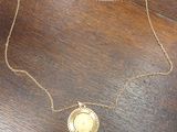 un gros plan d'un collier en or posé sur une table en bois