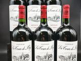 six bouteilles de vin rouge sont alignées sur une table