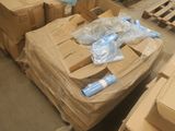 une pile de cartons et de colis posée par terre dans un entrepôt