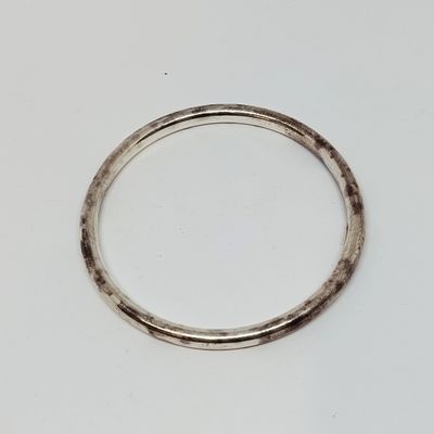 gros plan d'une bague en argent sur une surface blanche
