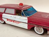 a red and white toy car with a red light on top of it