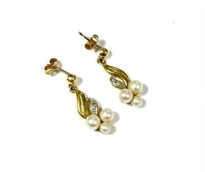 a pair of pearl and gold earrings on a white background