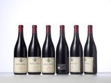 six bottles of wine are lined up on a table