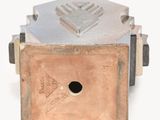 a metal object that is sitting on a white surface