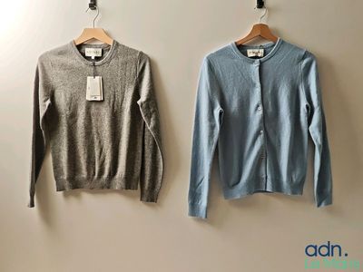 two sweaters hanging on the wall next to each other
