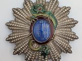 a close up of a silver and blue broochle on a white surface