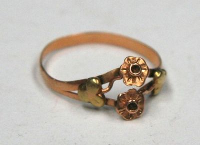 a gold ring with a flower design on it